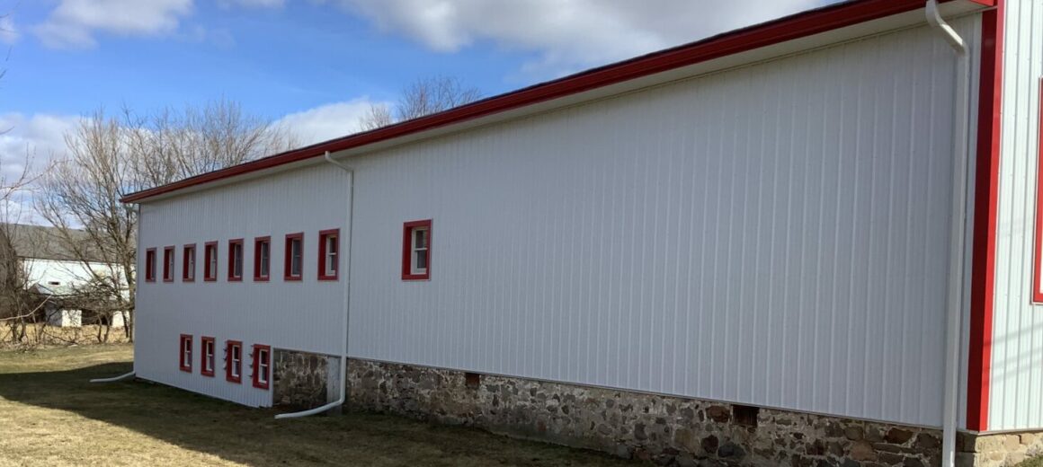 White corrugated metal siding, Barn Red metal trim, Scarlet Red 6k seamless gutters. White vinyl soffit, Macungie, PA, Lehigh County